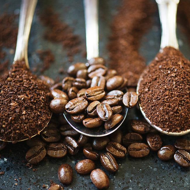 Closeup three spoons with ground coffee, coffee beans