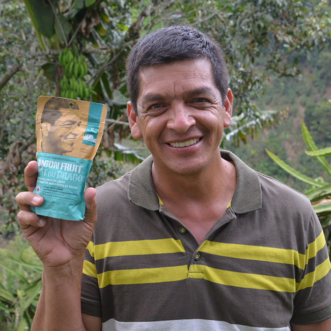 Male dragon fruit farmer holds package and smiles